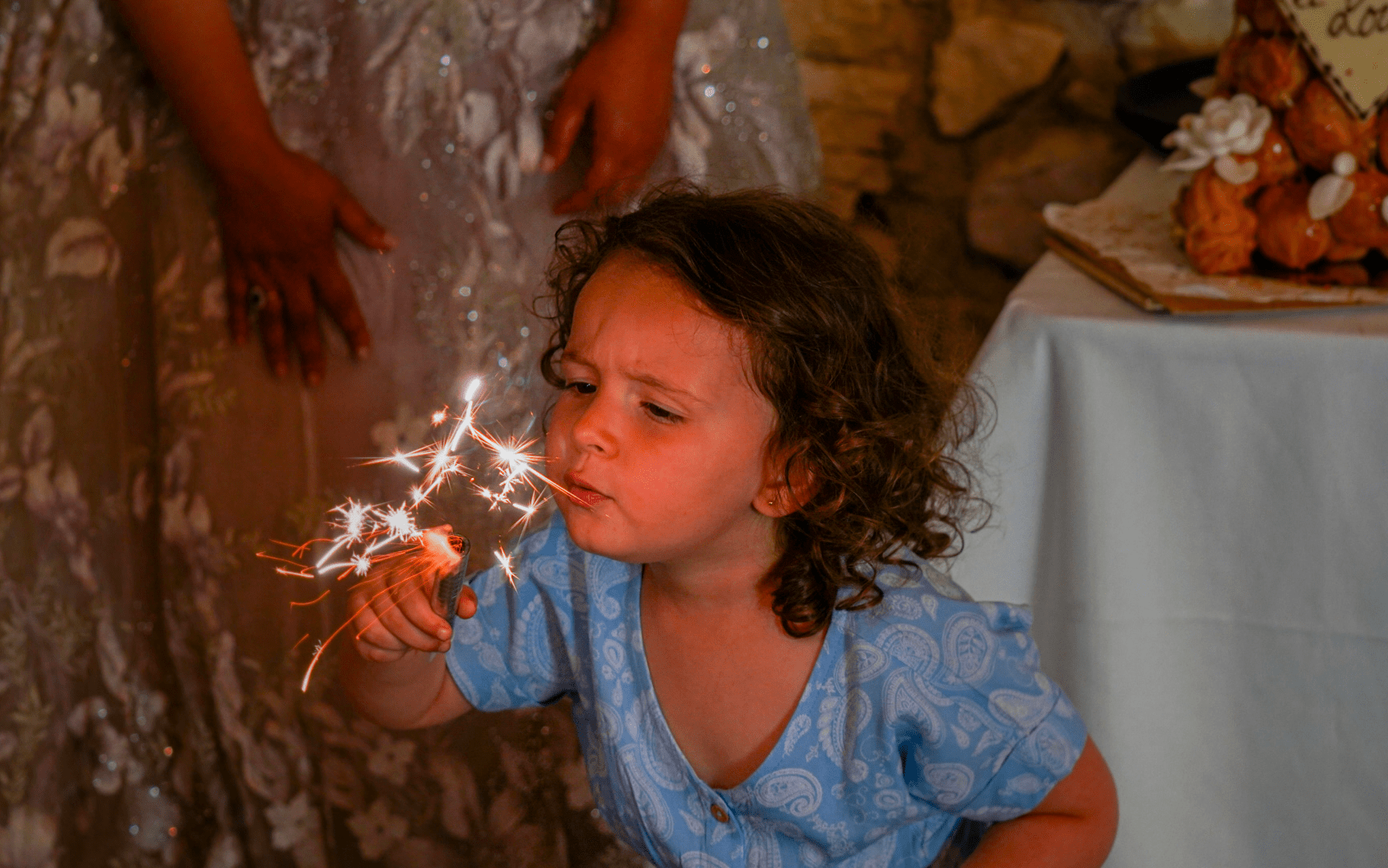 Photo du reportage de Joanna et Christophe, une jeune invité soufflant sur une bougie à étincelle