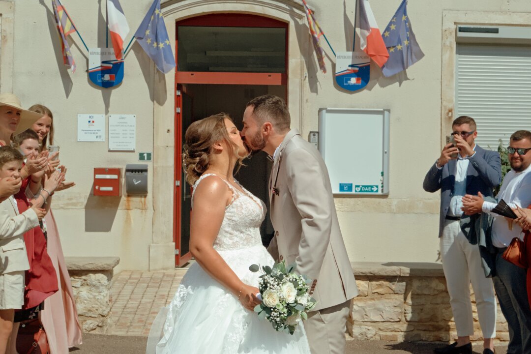 H_00090141 Photo du couple marié s'embrassant devant la mairie