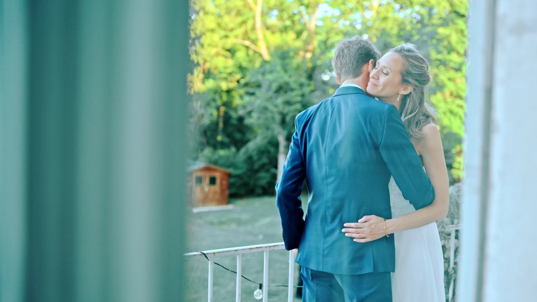 Le couple de mariés s’enlaçant à l’extérieur de la salle de réception