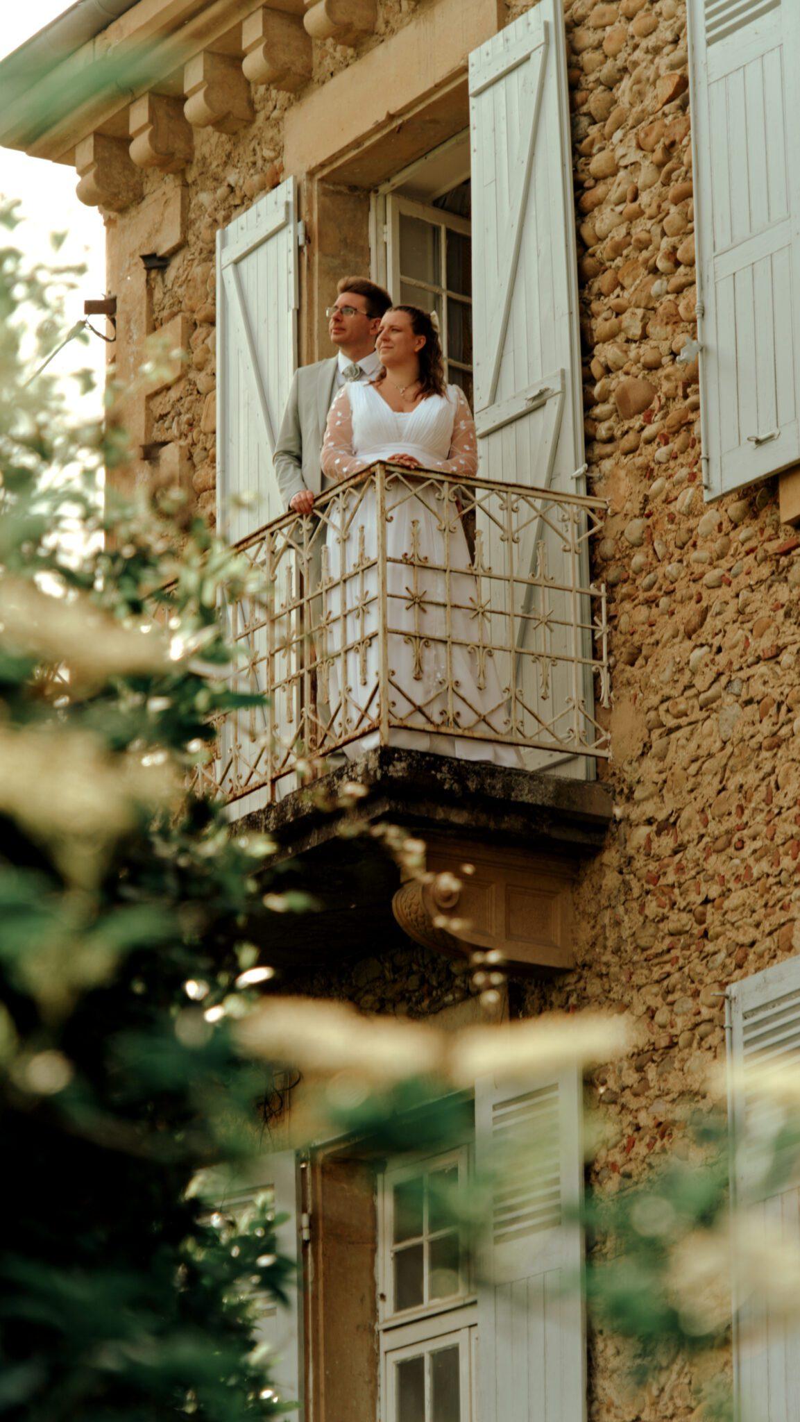Deux mariés sur un balcon de la réception de mariage